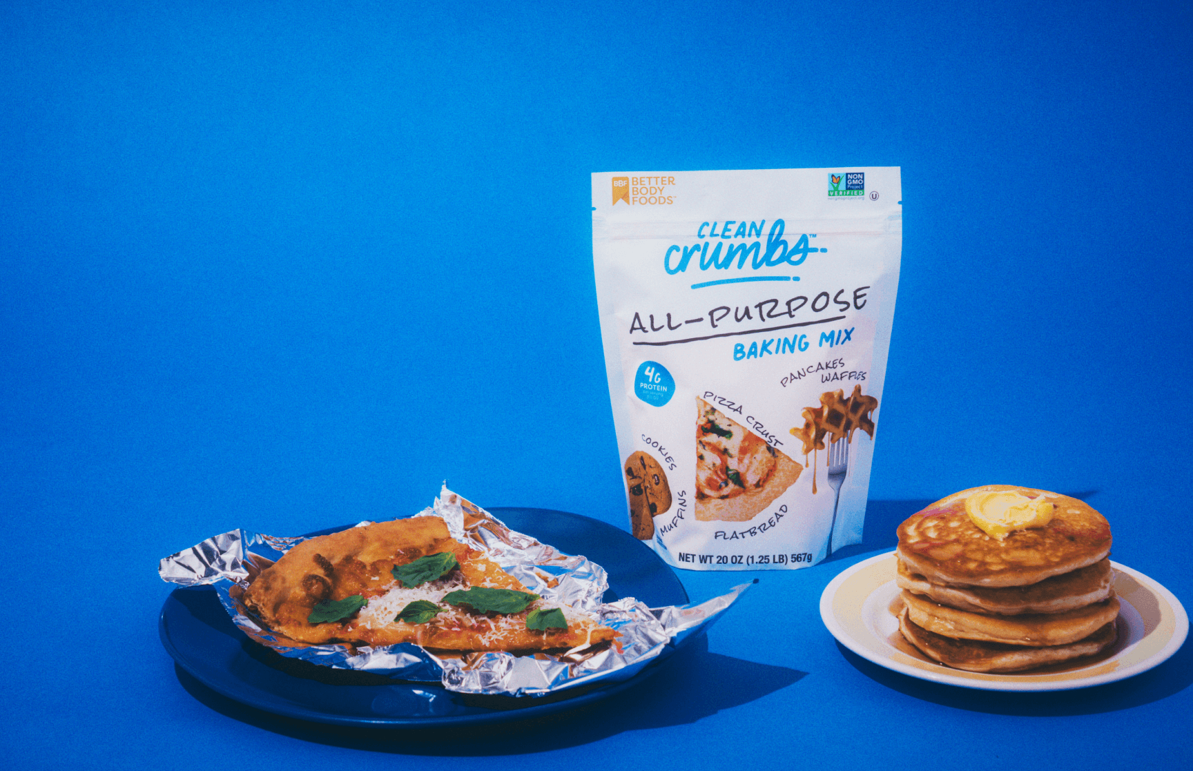 Clean Crumbs all-purpose baking mix bag with a pizza crust and a stack of pancakes