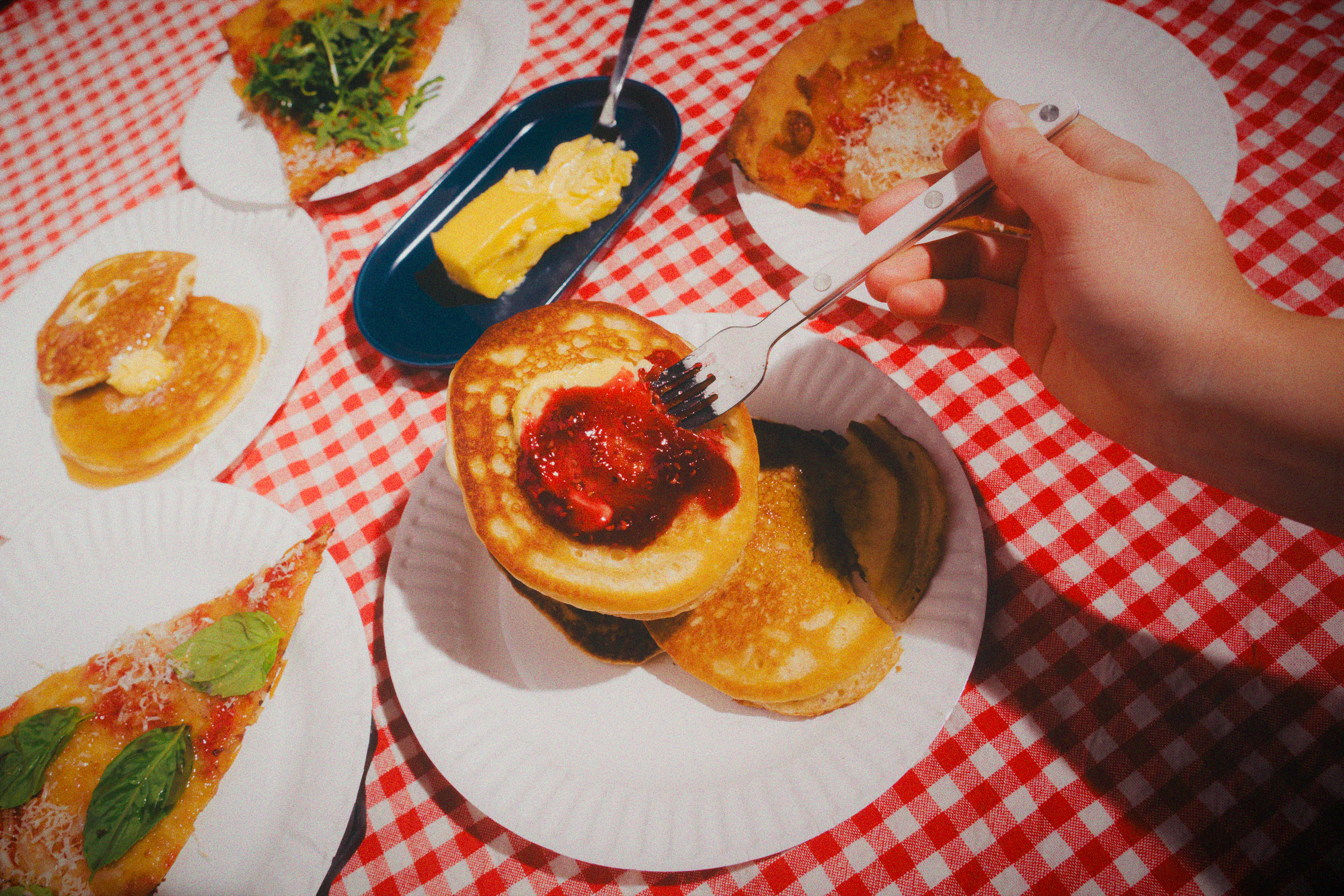 Pancakes with strawberry topping on a red checkered tablecloth
